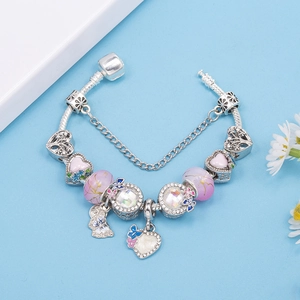 Bracciale con ciondoli argento con cuore rosa e perline viola su sfondo azzurro