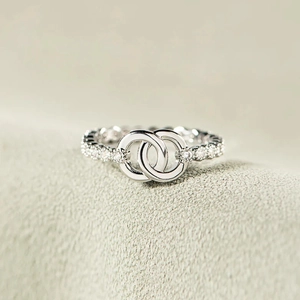 Elegant silver interlocking circle ring with micro-pave crystals on a textured background