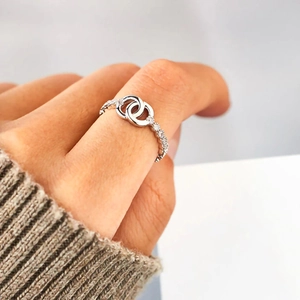 Macro shot of silver minimalist interlocking rings with micro-set shimmering zircon stones