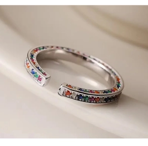 Macro-opname van een zilveren open ring met kleurrijke regenboog zirkonia stenen