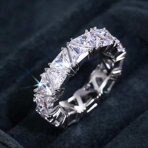 Macro view of triangle-cut cubic zirconia eternity ring on black velvet gift box