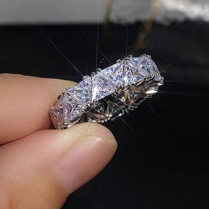Macro shot of silver eternity ring featuring triangle-cut cubic zirconia in claw setting