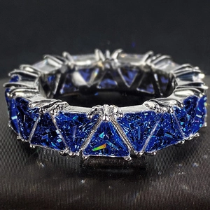Eternity band featuring triangle cut deep blue sapphires in a silver-tone metal setting