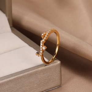 Detailed close-up of rose gold wave ring with sparkling white zircon in a beige jewelry box
