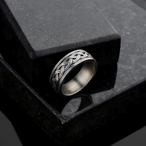 Bague large homme en argent antique avec motifs celtiques sur fond de marbre noir