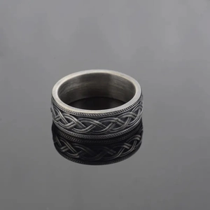Bague vintage en argent oxydé avec nœuds celtiques et bords torsadés sur fond sombre