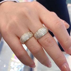 Close-up of gold-plated rings with pave-set pavé zircon stones on a model hand