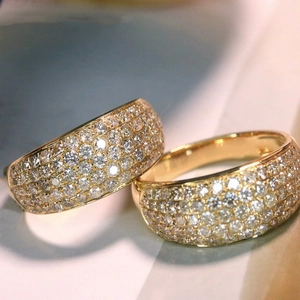 Close-up of dual gold rings with sparkling zircon pavé setting and polished finish