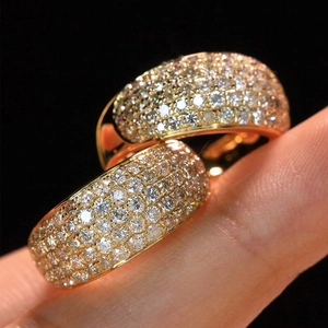Macro shot of wide gold ring with rows of brilliant-cut pavé zircons for wedding look
