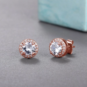 Macro detail of rose gold halo stud earrings with large round zircon and micro-pave stones