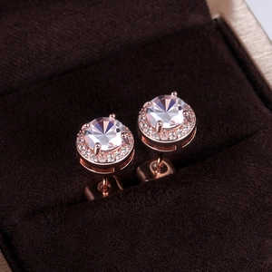 Macro view of rose gold stud earrings with round cubic zirconia and pavé halo detail