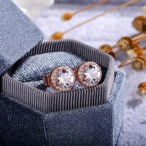 Close-up of rose gold halo stud earrings with round zircons in a blue velvet gift box