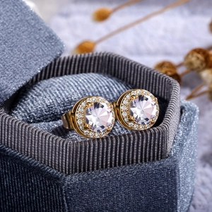 Close-up of golden halo stud earrings with lavender zircon and micro-paved white stones