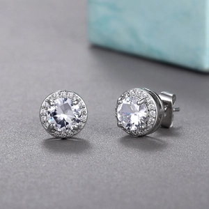 Detailed view of silver halo stud earrings with a brilliant round-cut center zircon