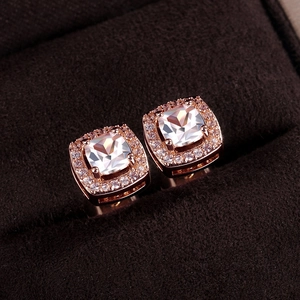 Macro shot of rose gold halo stud earrings with square-cut zircon in a velvet box
