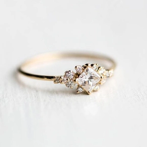 Detailed close-up of a princess cut diamond ring in a gold-plated vintage setting