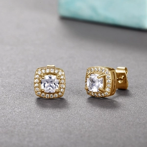 Close-up of gold halo stud earrings with square-cut zircon and pave setting detail