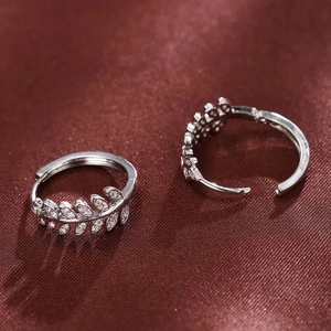 Detail of silver leaf hoop earrings with micro-pave zircons on red silk background