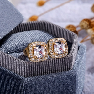 Close-up of square zircon stud earrings with halo setting in a grey velvet jewelry box