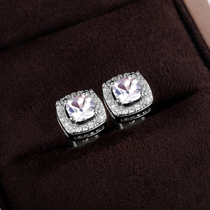 Macro shot of silver square stud earrings with central cubic zirconia and halo diamond setting