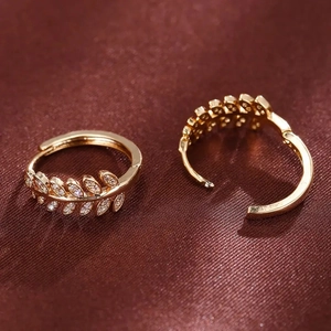 Macro shot of gold leaf earrings featuring micro-pave white zircons on brown silk