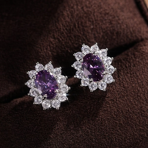 Macro shot of silver sunflower earrings with oval purple stones and white zircon accents