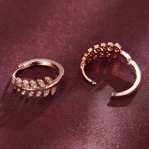 Macro view of rose gold leaf earrings with micro-set cubic zirconia on silk fabric