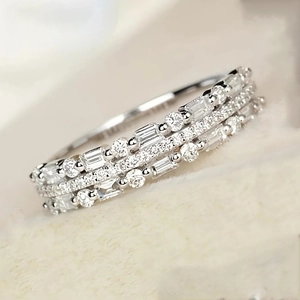 Macro shot of triple-layer silver band ring with round and baguette cut zircons