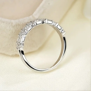 Macro shot of silver triple-layered ring with multi-stone pavé setting on white fabric