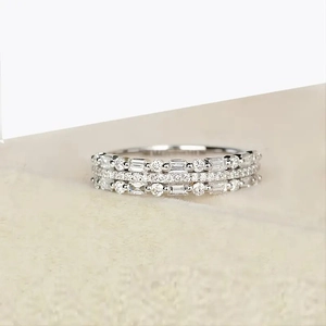 Close-up of a three-row sparkling silver ring with mixed round and baguette diamonds