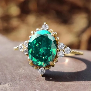 Macro detail of oval green gemstone ring with halo diamonds and vintage gold band