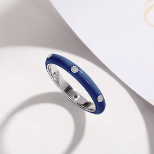 Macro shot of minimalist deep blue enamel ring featuring three inlaid zircon stones