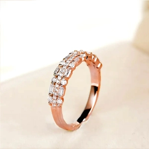 Macro view of rose gold multi-layered ring featuring baguette and round-cut crystals