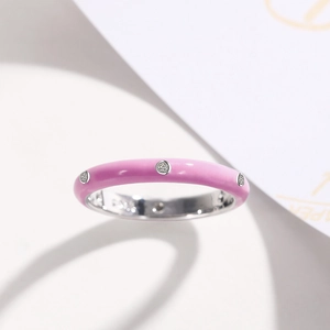 Close-up of pink enamel ring band with sparkling zircon stones and polished silver finish