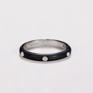 Macro detail of black matte band ring featuring inlaid white zircons and S925 hallmark