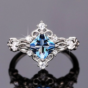 Macro view of princess cut blue gemstone ring with vintage hollow pattern and white zircons