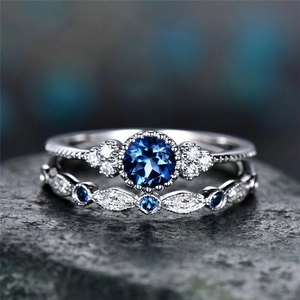 Elegante vintage zilveren saffier ringenset met blauwe steen en zirkonia halo