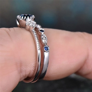 Macro shot of silver ring set featuring a large blue sapphire and fine pave side diamonds