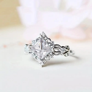 Detail of princess cut square aquamarine ring with intricate filigree silver band