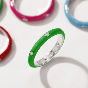 Macro detail of emerald green enamel ring with inlaid zircon stones and polished silver band