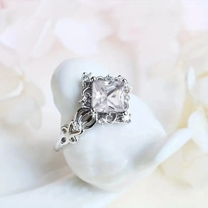 Macro detail of princess cut faux sapphire ring with ornate filigree and side zircon accents