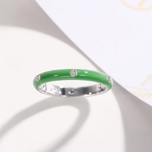 Macro shot of green enamel ring with inlaid zircons and silver interior finish