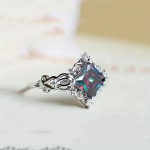 Macro shot of square cut iridescent gemstone ring with intricate silver hollow engravings