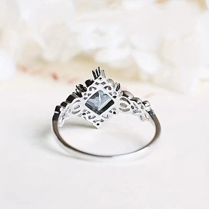 Detailed macro view of retro hollow pattern and square blue gemstone on silver ring