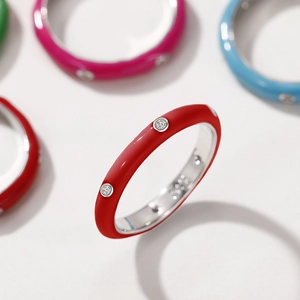 Macro shot of colorful enamel rainbow rings with inlaid cubic zirconia on silver metal