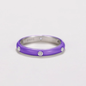 Detailed macro view of silver ring with purple enamel coating and circular zircon stones