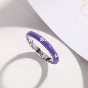 Close-up of minimalist purple enamel ring featuring three inlaid zircon stones on silver