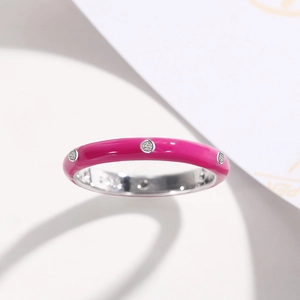 Macro detail of magenta enamel ring with sparkling zircon stones and silver finish