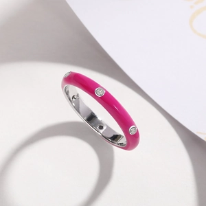 Close-up of minimalist rose red enamel ring with inlaid sparkling round zircon stones