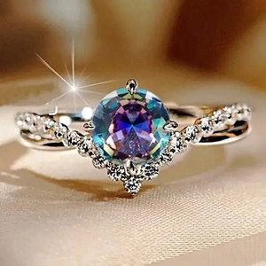 Macro shot of a four-prong V-shaped ring with a large iridescent zircon and micro-pave gems